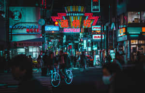 霓虹燈照亮夜晚的東京街道，有騎單車者和行人。