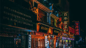 夜晚的街道，閃爍的霓虹燈招牌和傳統中式建築。 — 中文 壁紙