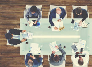 Six business professionals in suits collaborating around a glass conference table. — 辦公室 GIF 壁紙