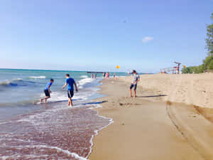 孩子們在陽光明媚的海灘上，在救生員塔旁的海浪中玩耍