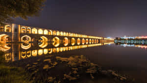 夜晚點亮的古石橋，在星空下的靜止水面上完美倒映。 — 通往泰拉比提亞之橋 壁紙