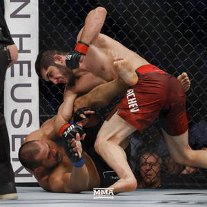 兩名男性拳手在MMA賽事中於籠內進行纏鬥。