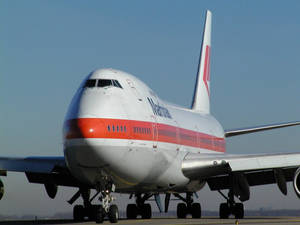 達美航空飛機在跑道上，起落架放下，天空清澈湛藍