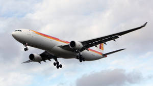 伊比利亞航空飛機喺多雲天空下放低起落架降落