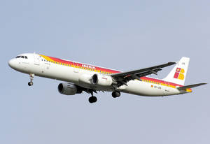 伊比利亞航空客機在飛行中，起落架放下，背景是晴朗的天空。