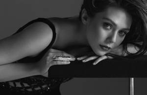 一位身穿黑色內衣的女性在工作室肖像中以直接的眼神擺姿勢。
