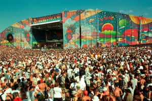 Woodstock 99音樂節人群面向色彩繽紛的舞台，背景是清澈的藍天。