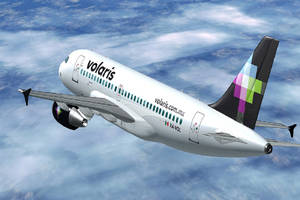 Volaris 飛機在明亮的藍天中飛越雲層