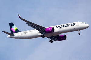 Volaris飛機飛行中，起落架放下，背景為藍天