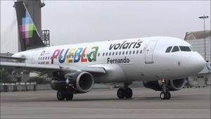 灰色天空下機場停機坪上的Volaris飛機Puebla Fernando