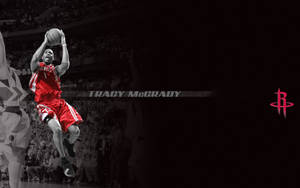 身穿紅色火箭隊球衣的 Tracy McGrady 在場館中跳起投籃。