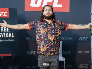 UFC拳手Jorge Masvidal在記者會上穿著老虎花卉襯衫擺姿勢。