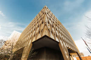 藍天下帶有菱形圖案外牆的現代幾何建築 — 建築 壁紙