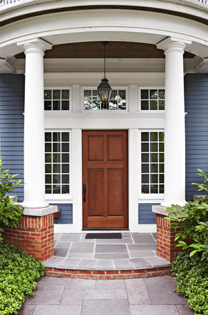 藍色房子的前門廊，有白色柱子和木門。