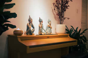 三尊佛像坐在鋼琴上，帶有擴香器和植物，在舒適的房間裡。