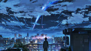 屋頂上的人看著藍色燈光在夜間落在城市上空
