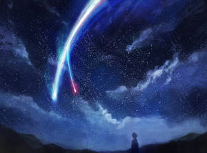 一個人觀看彩色彗星劃過星空夜空的剪影。