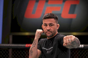 MMA拳手穿著黑色T恤在UFC八角籠內舉起拳頭擺姿勢。