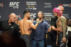 兩名UFC拳手在稱重活動中以粉紅色頭髮和紋身互相對峙。
