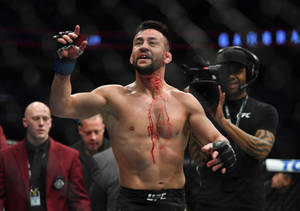 UFC拳手在八角籠內胸前帶血慶祝勝利。