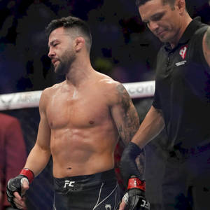 UFC拳手帶有紋身，在八角籠中由裁判照料。