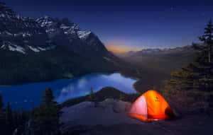 一個橙色帳篷喺懸崖邊緣溫暖咁發光，上面係星空湖同雪山。