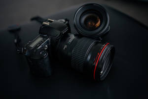 專業 DSLR 相機和鏡頭在工作室燈光下的深色表面上