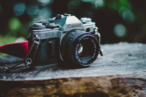 復古 Canon AE-1 菲林相機在木質表面上，綠色背景模糊。