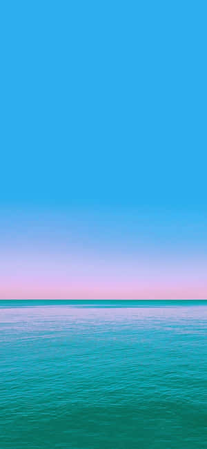 平靜的海洋在暮色地平線上與粉彩天空相遇
