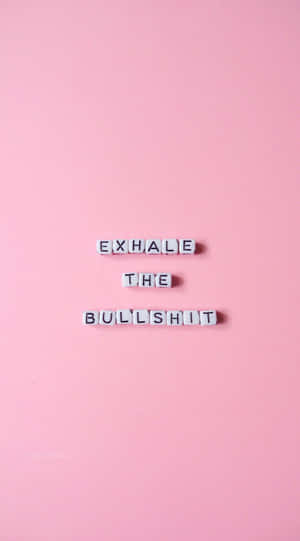 白色字母瓷磚在粉紅色背景上拼出 exhale the bullshit。