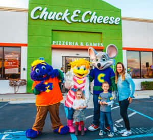 家庭與Chuck E. Cheese吉祥物在餐廳外日落時分。