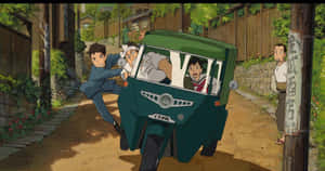 一個男孩推著一輛載有孩子的綠色三輪車，穿過陽光明媚的日本村莊街道。