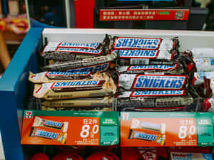 貨架上的 Snickers 朱古力棒，附有中文價格標籤。