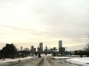 被雪覆蓋的城市道路，遠處城市天際線，多雲天空