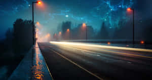 夜晚潮濕的道路，發光路燈和汽車燈光軌跡，在星空下。 — 桌面美學 壁紙