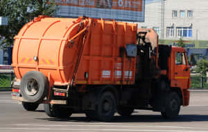 城市街道上的橙色垃圾車（白天） — 高對比 壁紙