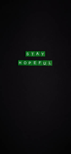 深色背景上帶有 stay hopeful 訊息的綠色拼字磚塊。