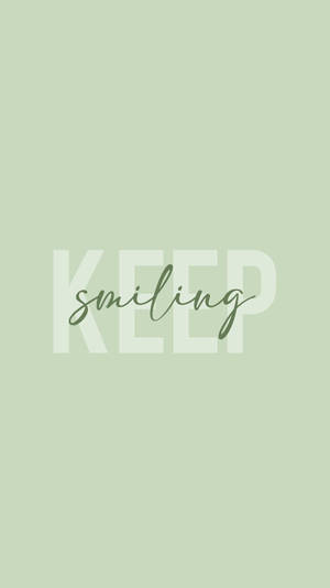 鼠尾草色背景上以白色和綠色顯示的勵志語句 'KEEP smiling'。