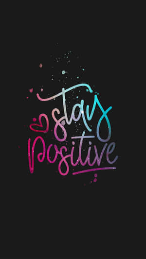 Stay positive 勵志名言，以彩色閃亮字體書寫於黑色背景上。