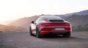 紅色保時捷911 Carrera GTS在日落時停泊在山路上。