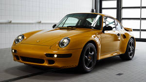 金色保時捷911 Turbo在乾淨的瓷磚車庫中，配有大窗戶。