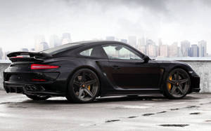 黑色保時捷911 Turbo S在屋頂上，背景是城市天際線。