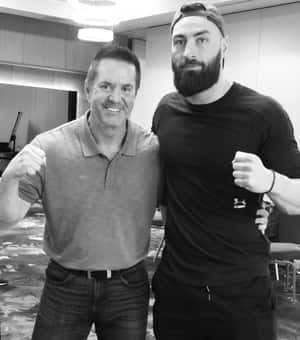 兩名男子在室內以黑白畫面一起握拳。