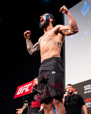 UFC拳手在舞台上高舉拳頭慶祝勝利。