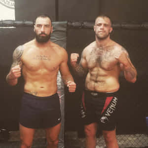 兩名紋身MMA鬥士在格鬥籠內舉起拳頭擺姿勢。