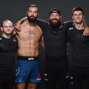 四位男性UFC拳手穿著運動服一起擺姿勢，紋身清晰可見。