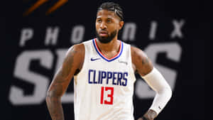 籃球運動員保羅·喬治身穿快艇隊13號球衣，帶有紋身和專注的表情。