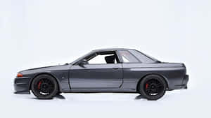 深灰色日產Skyline GT-R，配備黑色輪圈和紅色制動卡鉗，在白色工作室中。