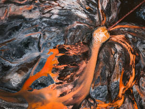 熔岩流在火山爆發中傾瀉到深色火山岩上。