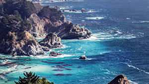 在明亮日光下，崎嶇的海岸懸崖與碧綠的海水和拍岸的浪花。 — 海 壁紙